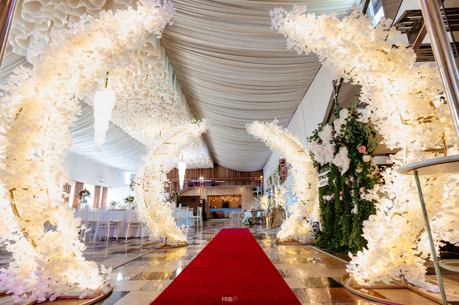 Arcadă florală luminoasă cu covor roșu