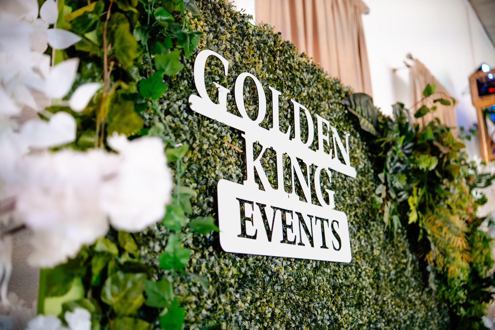 Panou cu logo Golden King Events pe perete verde